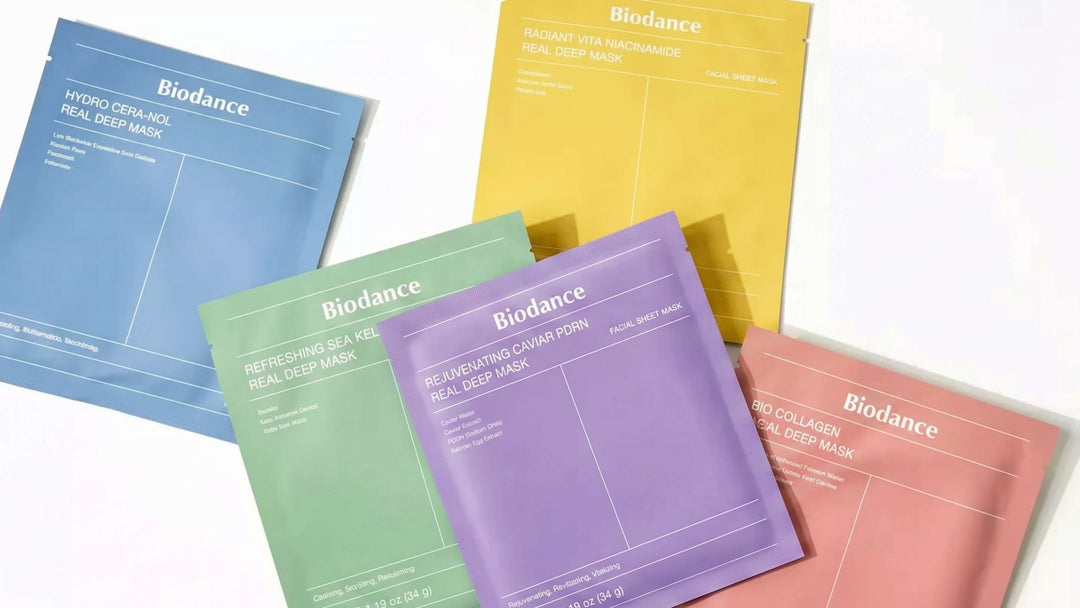 En förpackning av Anua PEACH 70 Niacin Serum Mask med en återfuktande serumflaska och en mogen persika i en harmonisk rosa och persikofärgad komposition.