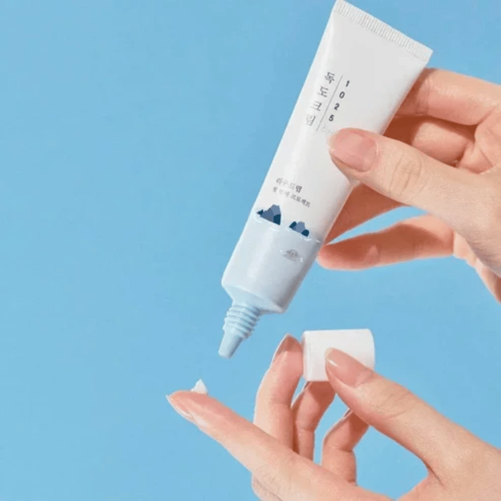 Round Lab 1025 Dokdo Eye Cream tub med lätt kräm som appliceras på fingertoppen för skonsam vård av känslig hud runt ögonen