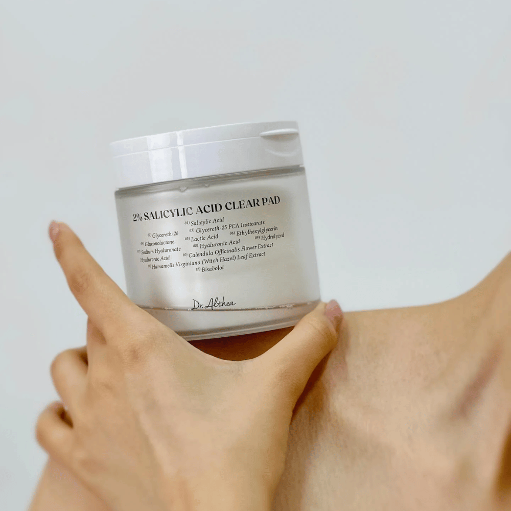 Dr. Althea 2% Salicylic Acid Clear Pad hålls i handen. Toner pads med 2% salicylsyra som exfolierar skonsamt, lugnar huden och förbättrar hudstrukturen.
