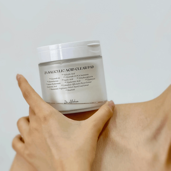Dr. Althea 2% Salicylic Acid Clear Pad hålls i handen. Toner pads med 2% salicylsyra som exfolierar skonsamt, lugnar huden och förbättrar hudstrukturen.