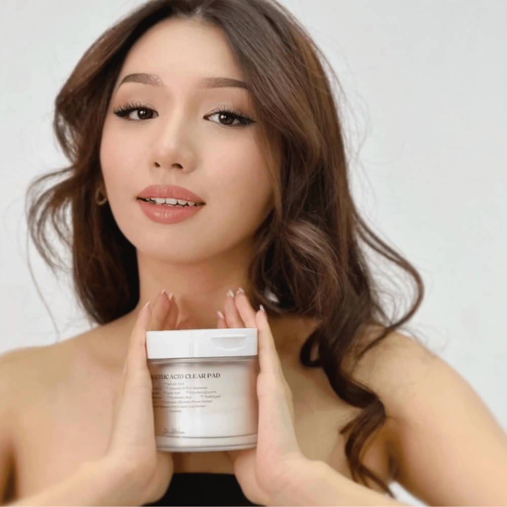 Modell håller Dr. Althea 2% Salicylic Acid Clear Pad framför ansiktet. Exfolierande toner pads med salicylsyra som rengör porer, balanserar talg och ger klarare hud.