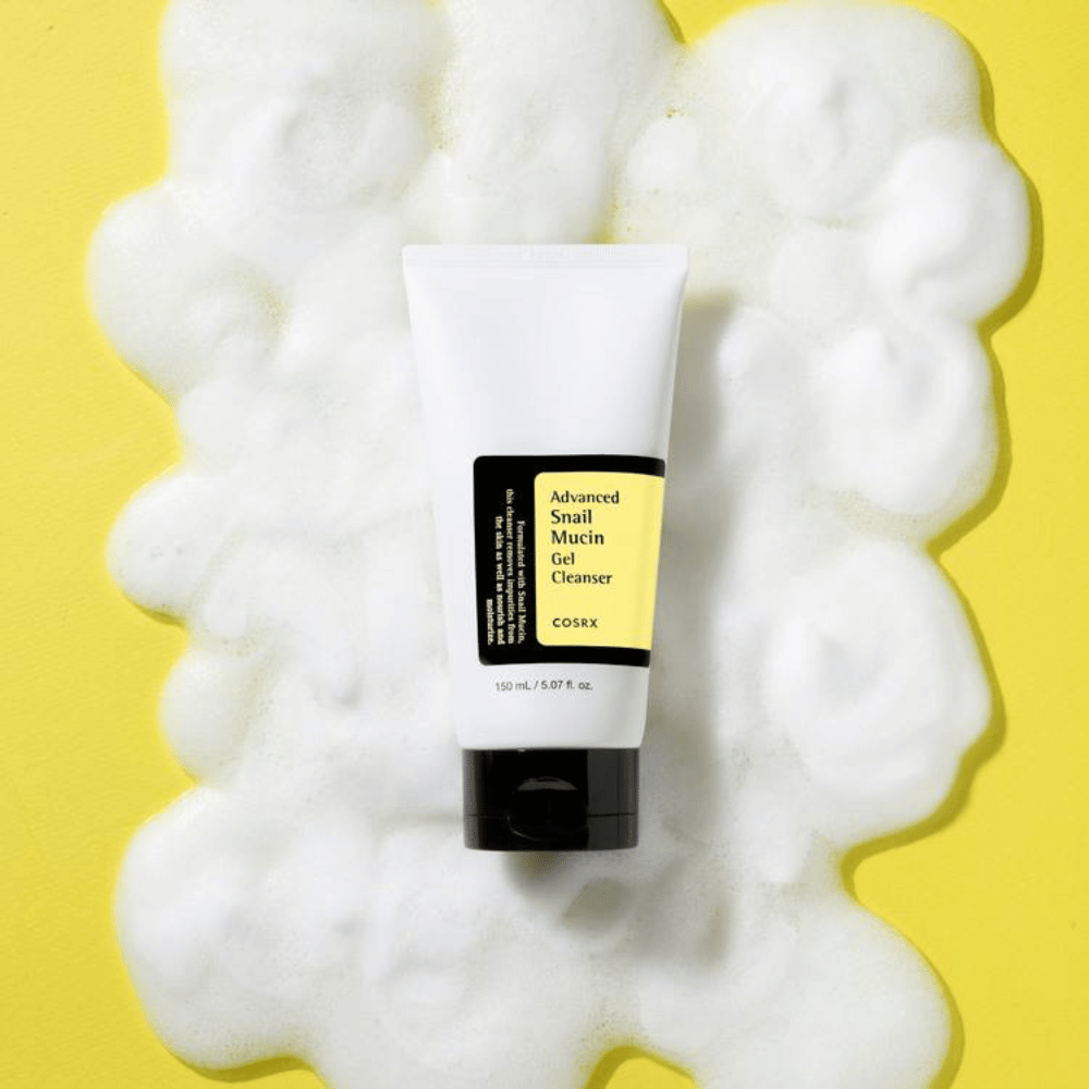 COSRX Advanced Snail Mucin Gel Cleanser 150 ml omgiven av rikligt lödder på gul bakgrund – mild koreansk ansiktsrengöring med snigelslem för återfuktning och lyster.