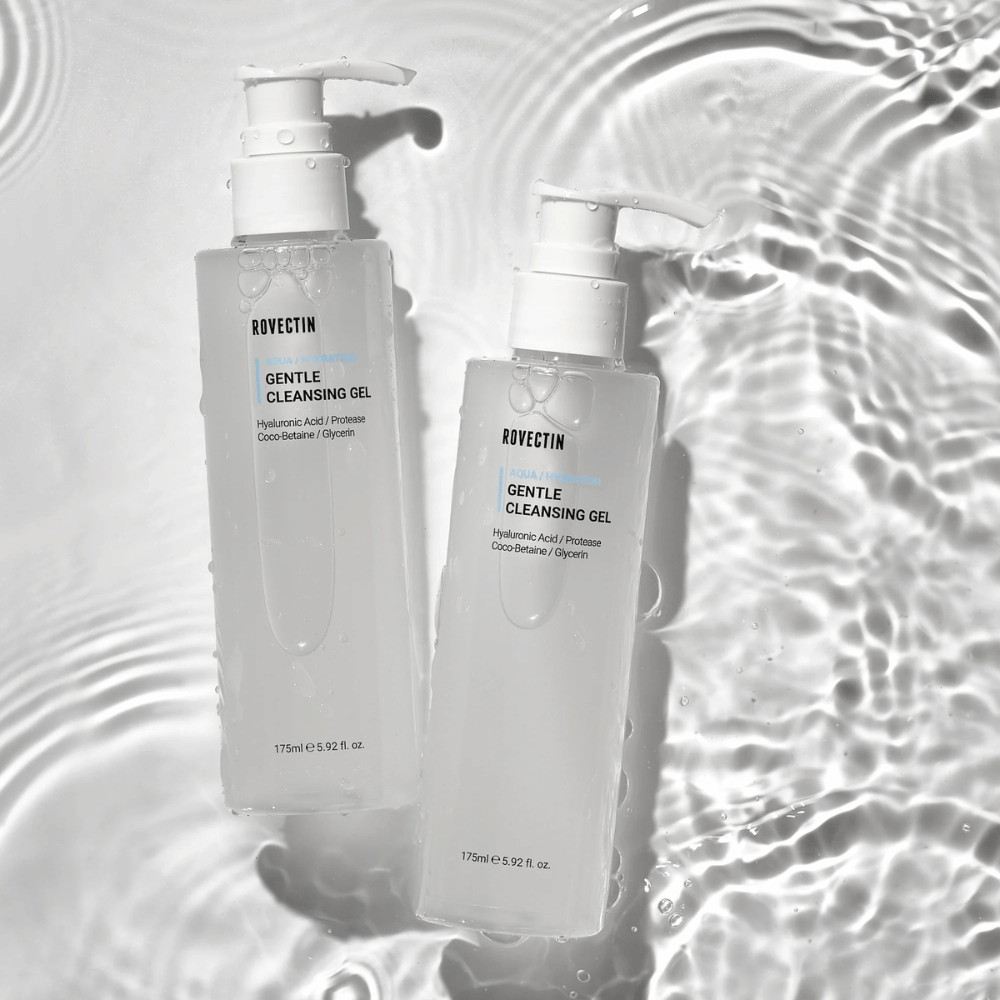 Två genomskinliga pumpflaskor med Rovectin Gentle Cleansing Gel, omgivna av vatten och reflektioner på en ljus yta.