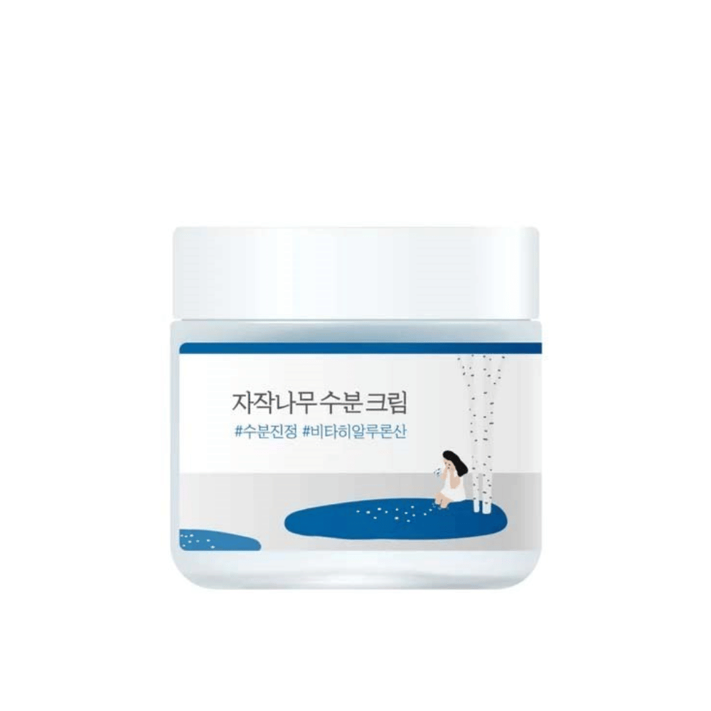 Round Lab Birch Juice Moisturizing Cream i transparent burk med vit lock och blå etikett med illustration av björk och flicka, frilagd mot vit bakgrund.