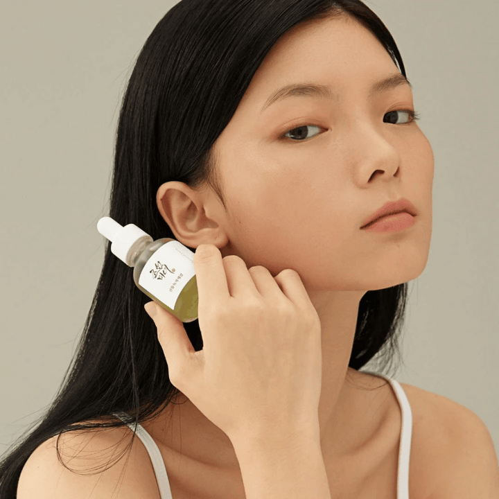 Modell håller Beauty of Joseon Calming Serum vid kinden – grönt te och panthenol som stärker hudbarriären.