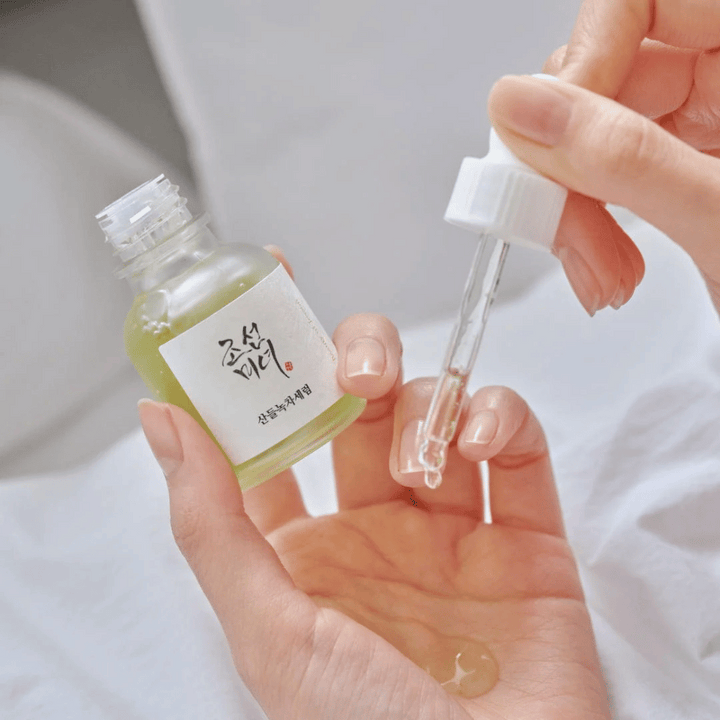 Hand droppar Beauty of Joseon Calming Serum Green Tea + Panthenol på huden – lugnande koreanskt serum för känslig hy.