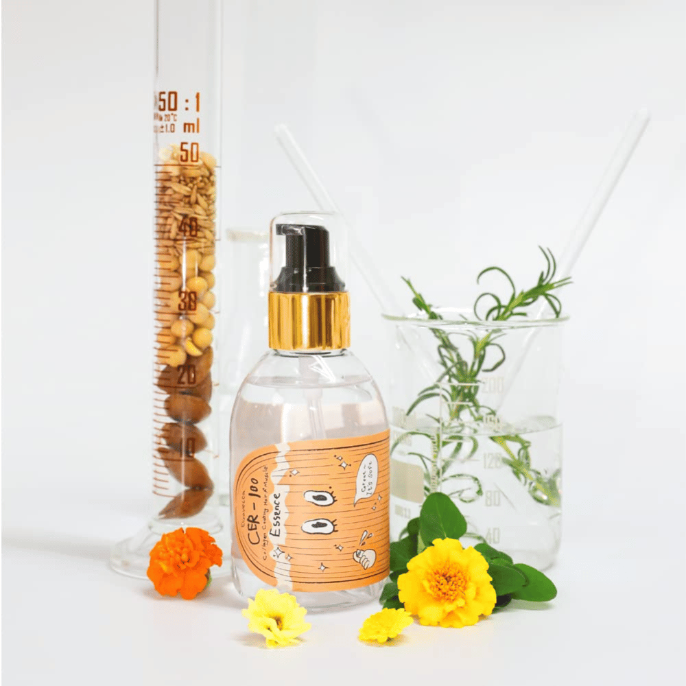 CER-100 Hair Essence tillsammans med blommor och laboratorieglas som framhäver ingredienser och hårvård.