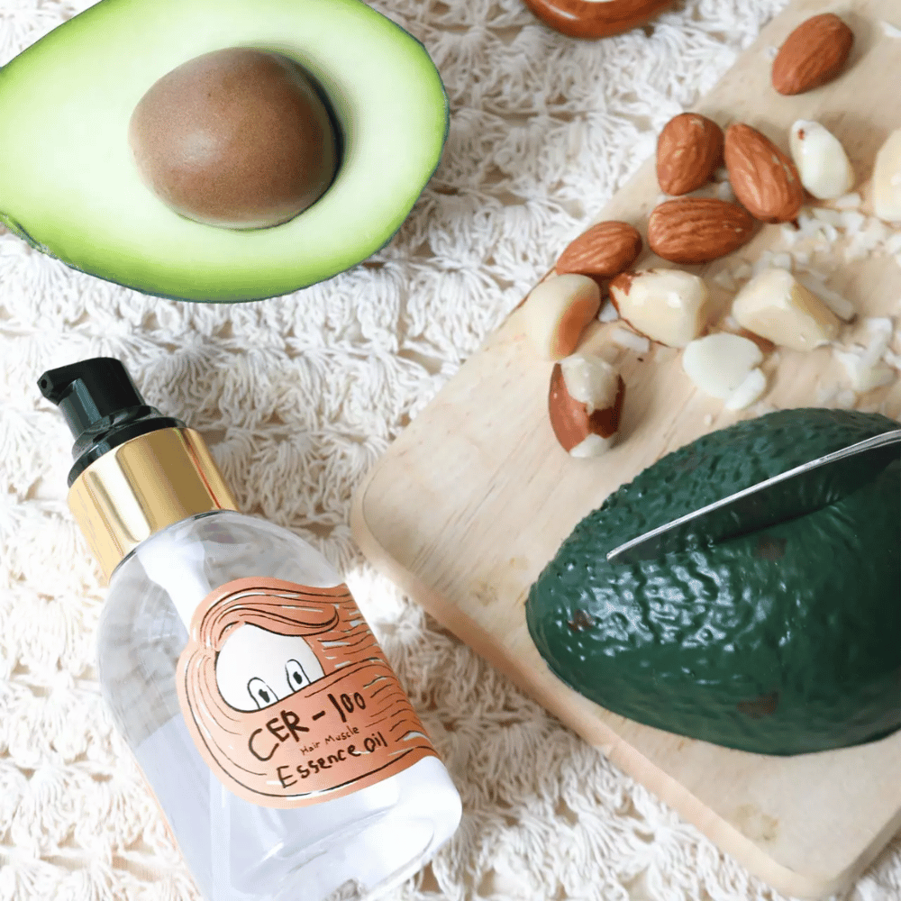 Elizavecca CER-100 Hair Muscle Essence Oil ingredienser – närbild med avokado och växtoljor som visar en näringsrik hårolja som hjälper till att mjukgöra och vårda håret.