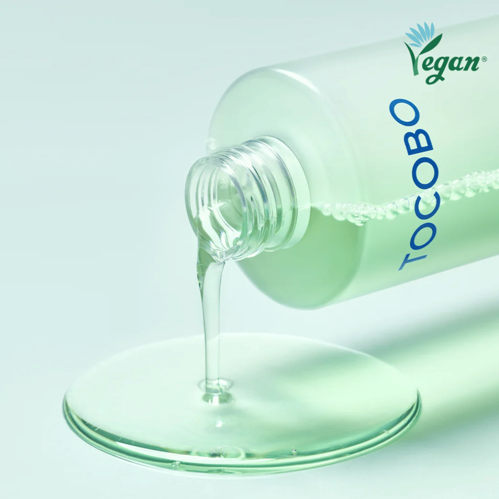 Närbild av TOCOBO Cica Calming Aqua Toner som hälls ut för att framhäva den klara, lätta och svalkande konsistensen i produkten.