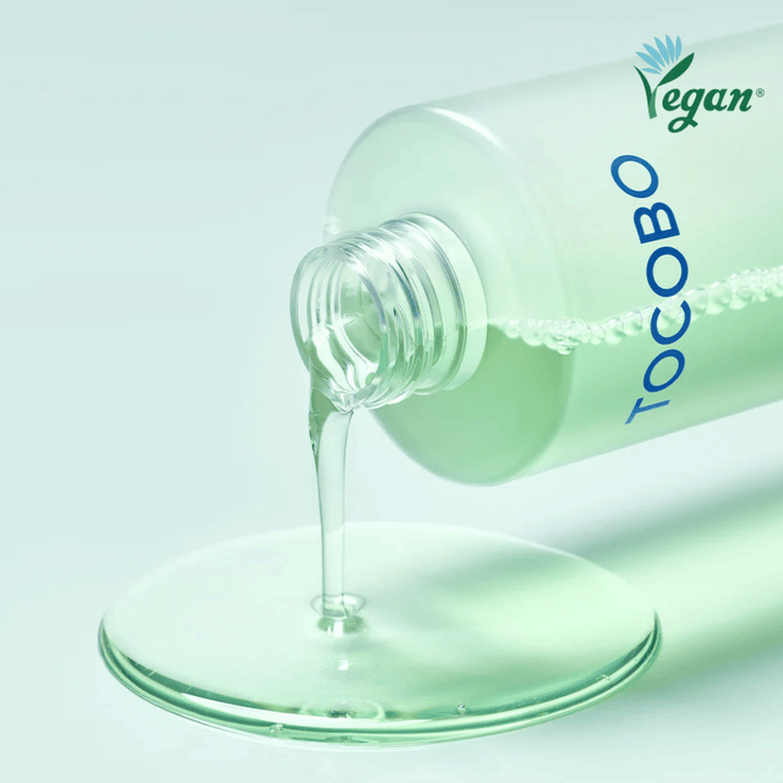 Närbild av TOCOBO Cica Calming Aqua Toner som hälls ut för att framhäva den klara, lätta och svalkande konsistensen i produkten.