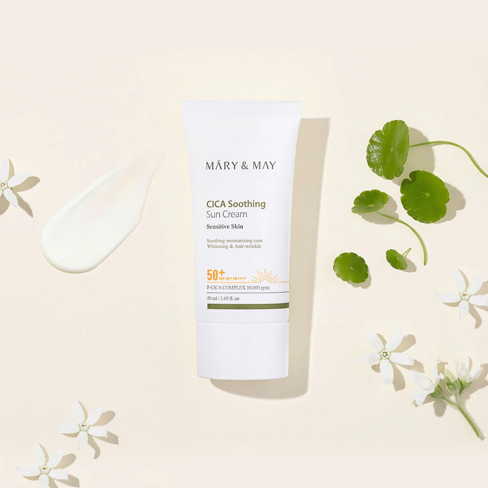 Mary&May CICA Soothing Sun Cream SPF50+ PA++++ presenterad tillsammans med en krämtextur, centella-blad och vita blommor. Bilden lyfter fram produktens lugnande egenskaper och fokus på känslig hud.