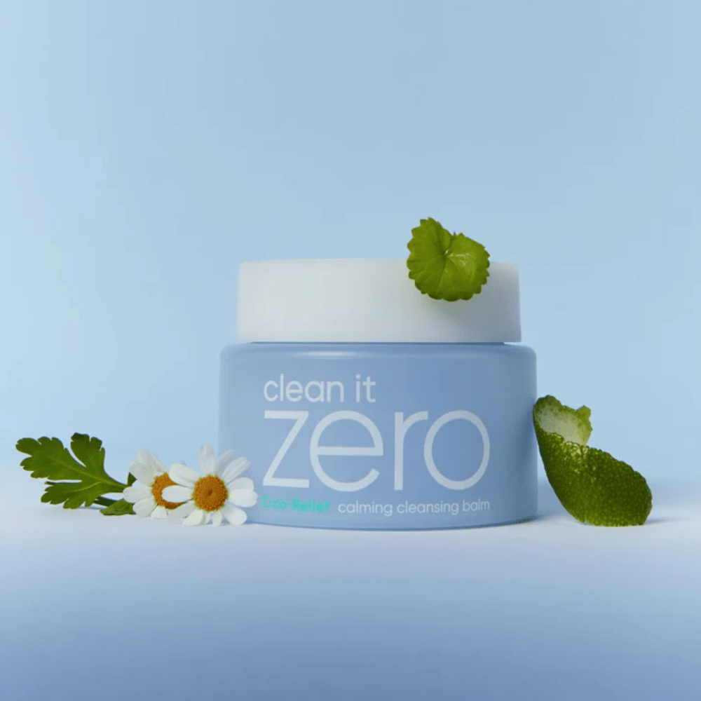 Clean It Zero Cica-Relief Calming Cleansing Balm placerad med växter och blommor, illustrerar mild rengöring med lugnande CICA för känslig och irriterad hud.