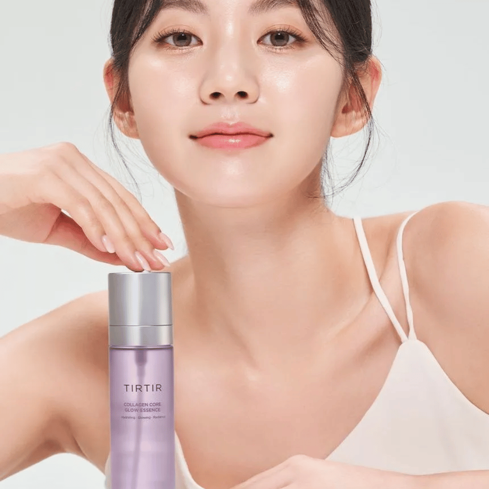 Kvinna med strålande hy poserar med TIRTIR Collagen Core Glow Essence – en lystergivande essence för fastare och återfuktad hud.