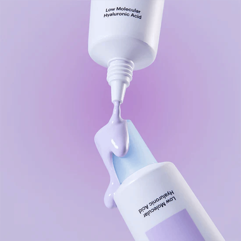 Närbild på Torriden DIVE IN Tone Up Sun Cream Purple där den lila krämen appliceras från tuben för att illustrera produktens konsistens.