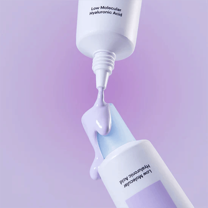Närbild på Torriden DIVE IN Tone Up Sun Cream Purple där den lila krämen appliceras från tuben för att illustrera produktens konsistens.