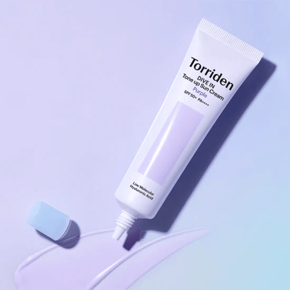 Öppen tub av Torriden DIVE IN Tone Up Sun Cream Purple med lila tonad solkrämstextur som visar produktens färgkorrigerande formula.