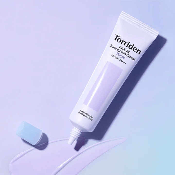 Öppen tub av Torriden DIVE IN Tone Up Sun Cream Purple med lila tonad solkrämstextur som visar produktens färgkorrigerande formula.