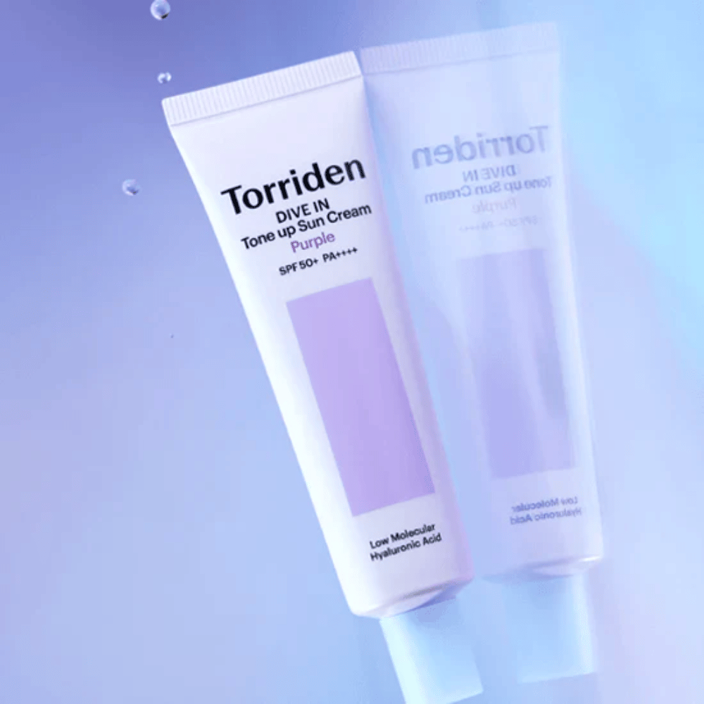Torriden DIVE IN Tone Up Sun Cream Purple SPF50+ PA++++ fotograferad mot mjuk lila bakgrund som framhäver produktens ljusreflekterande design.