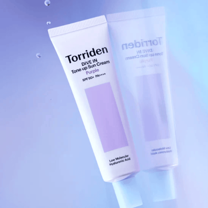 Torriden DIVE IN Tone Up Sun Cream Purple SPF50+ PA++++ fotograferad mot mjuk lila bakgrund som framhäver produktens ljusreflekterande design.