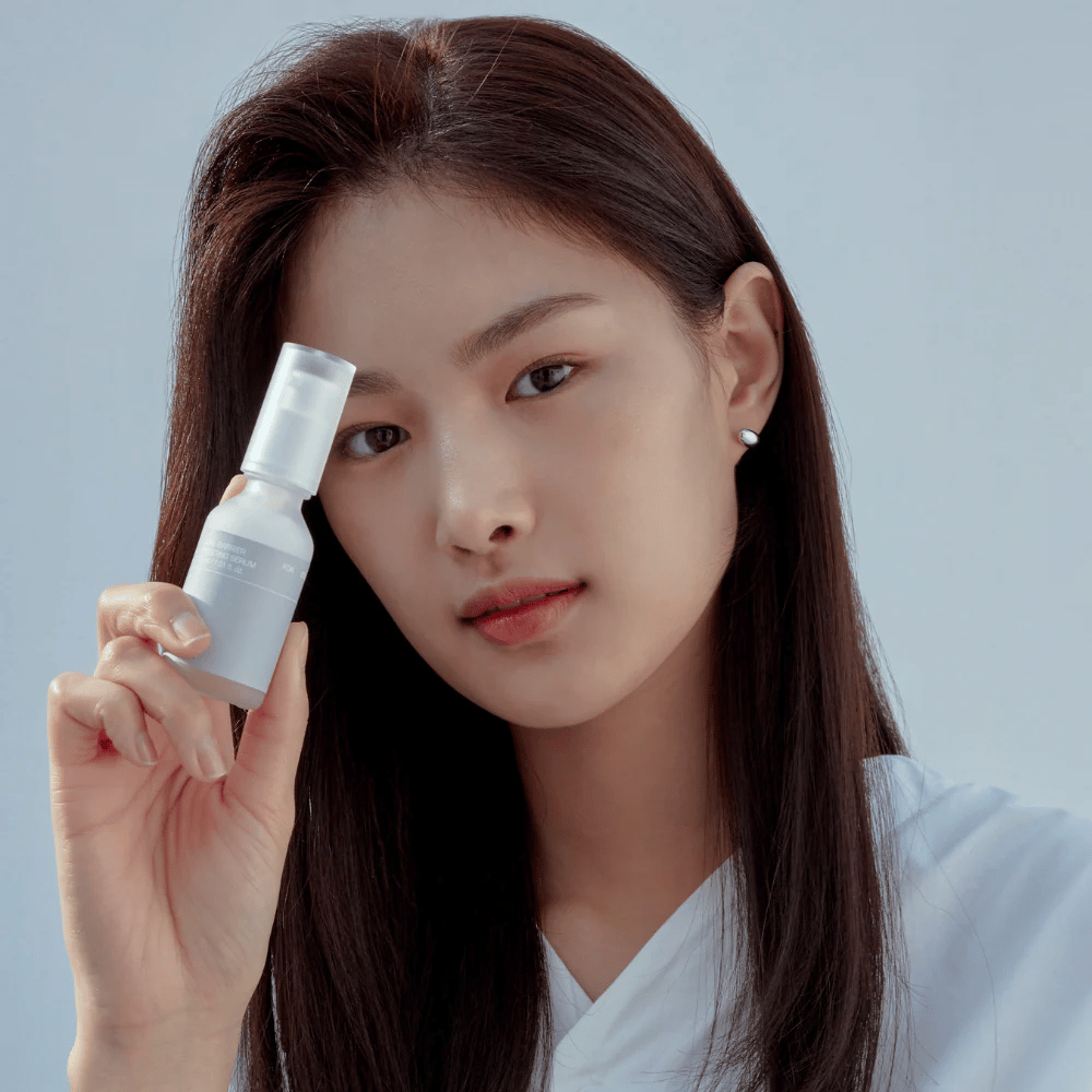 Modell håller Celimax Dual Barrier Boosting Serum, koreansk hudvård som stärker hudbarriären och lugnar känslig hud.