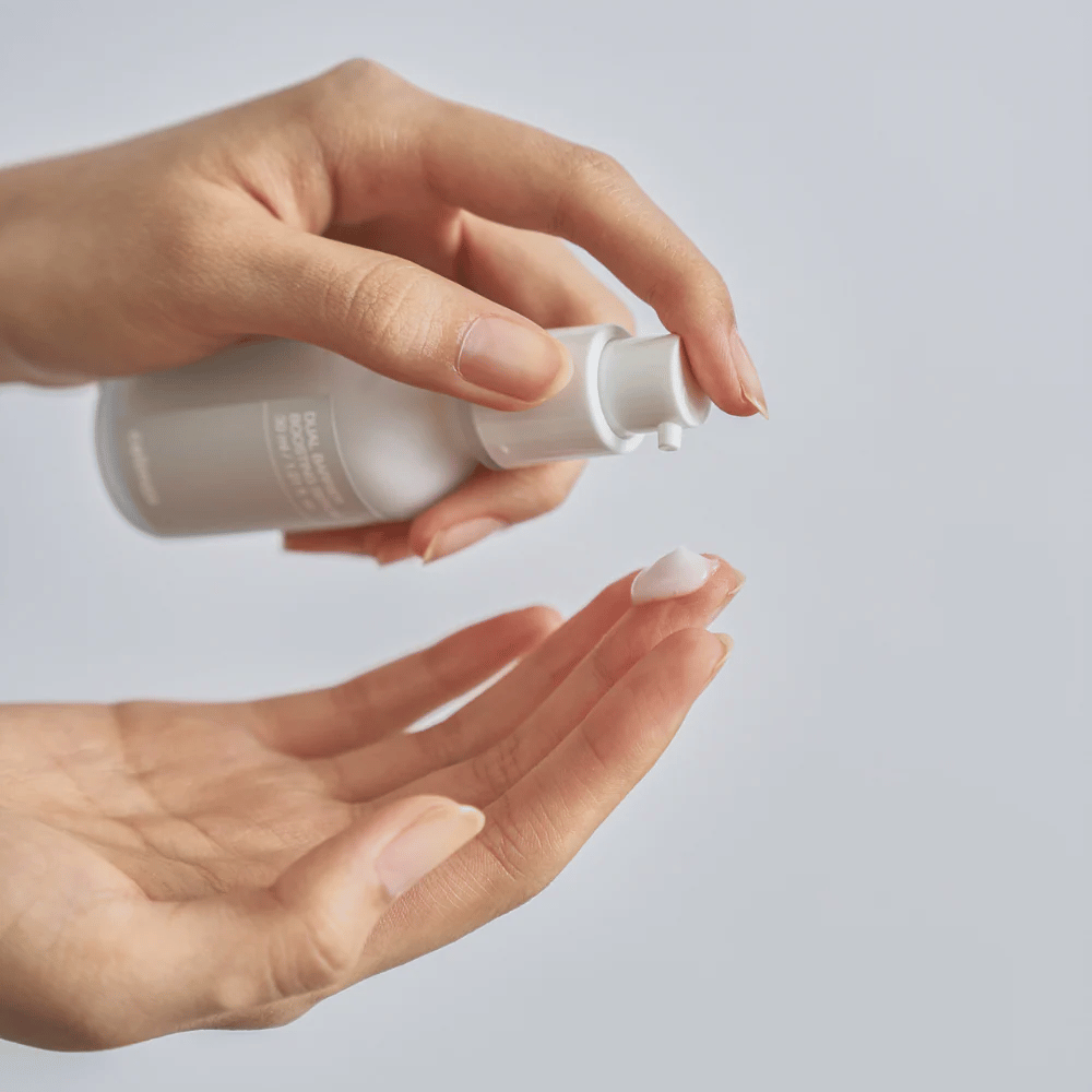 Celimax Dual Barrier Boosting Serum pumpas ut i handen, lätt serumtextur för daglig hudvård och barriärreparation.