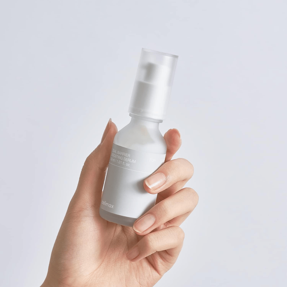 Celimax Dual Barrier Boosting Serum i hand, minimalistisk förpackning som visar barriärstärkande koreanskt serum för känslig hud.