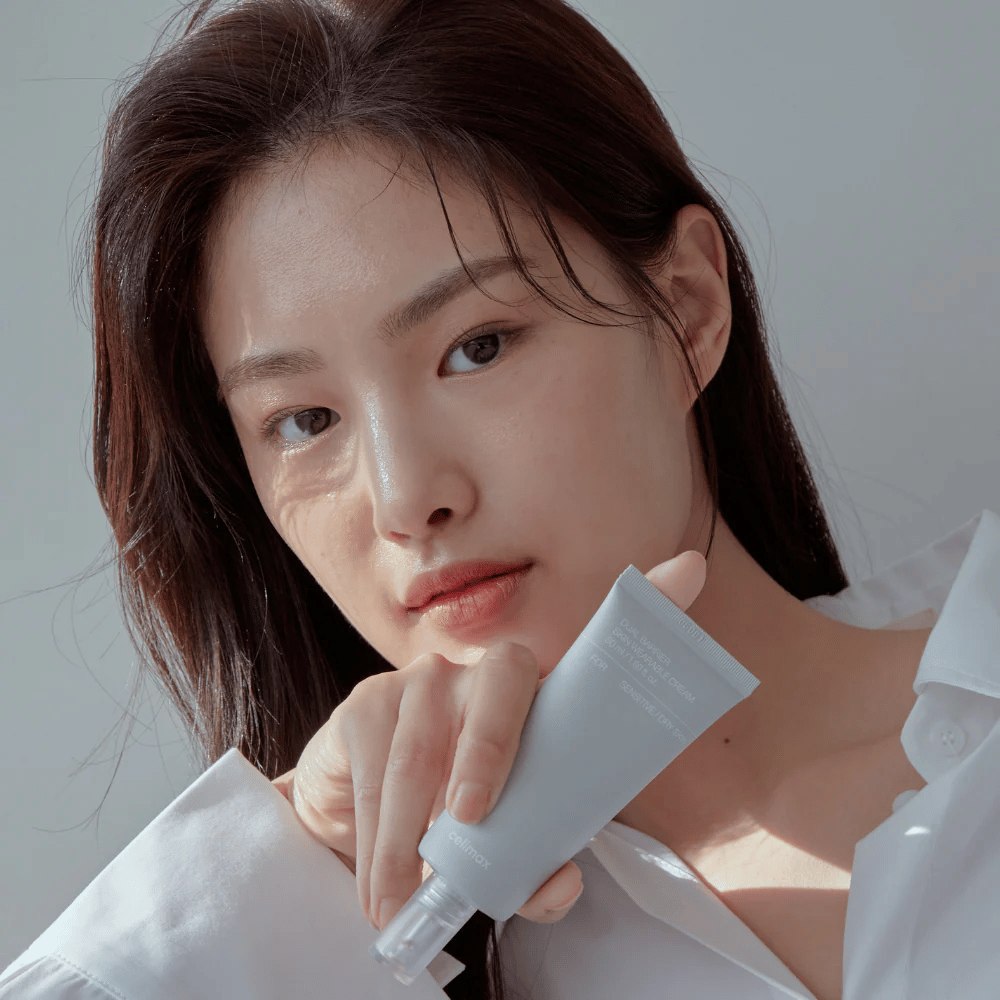 Modell som håller Celimax Dual Barrier Skin Wearable Cream, lugnande och barriärstärkande ansiktskräm för känslig hud och torr hud.