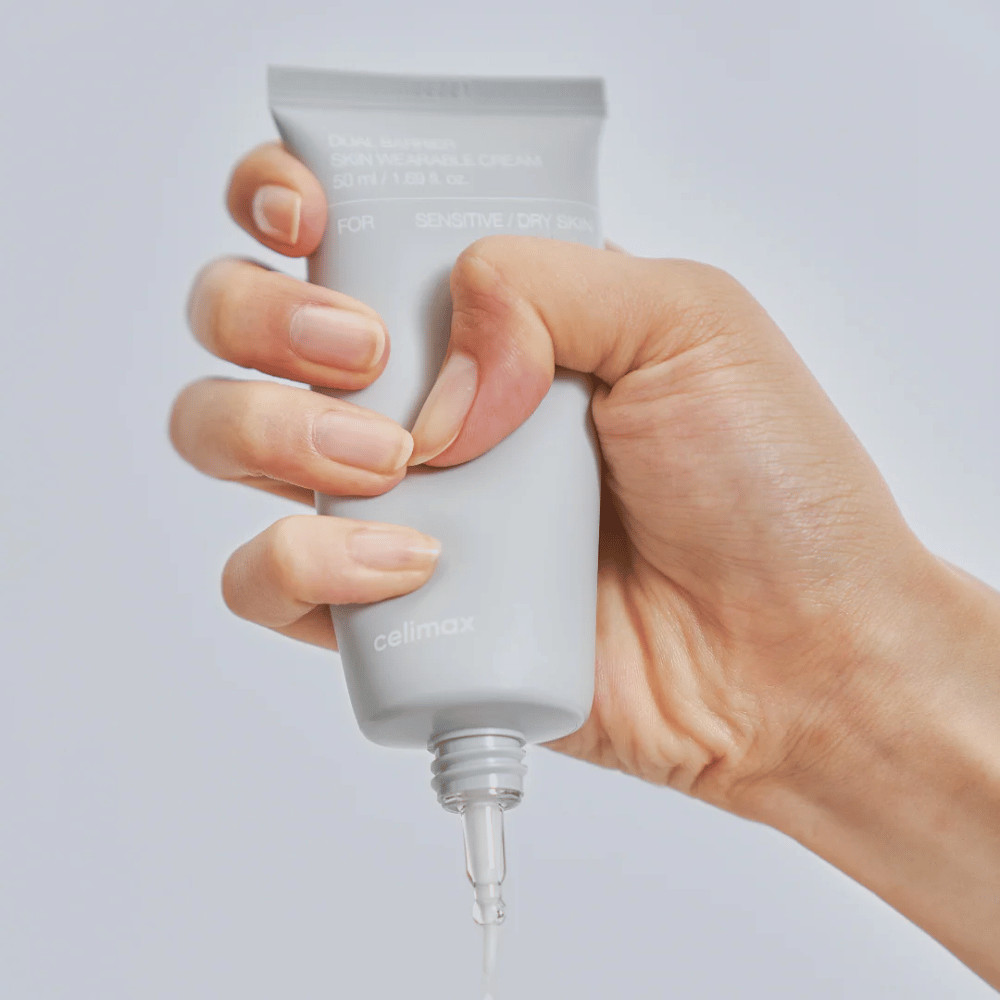 Hand som applicerar Celimax Dual Barrier Skin Wearable Cream, barriärstärkande ansiktskräm för känslig och torr hud som ger långvarig återfuktning och skyddar hudbarriären.