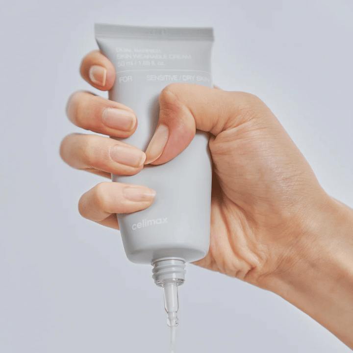 Hand som applicerar Celimax Dual Barrier Skin Wearable Cream, barriärstärkande ansiktskräm för känslig och torr hud som ger långvarig återfuktning och skyddar hudbarriären.