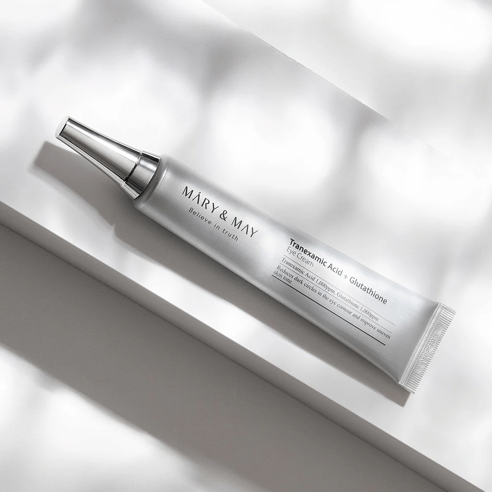 Närbild av Mary&May Tranexamic Acid + Glutathione Eye Cream med metallapplikator, utvecklad för att ljusa upp mörka ringar och jämna ut hudtonen runt ögonen.