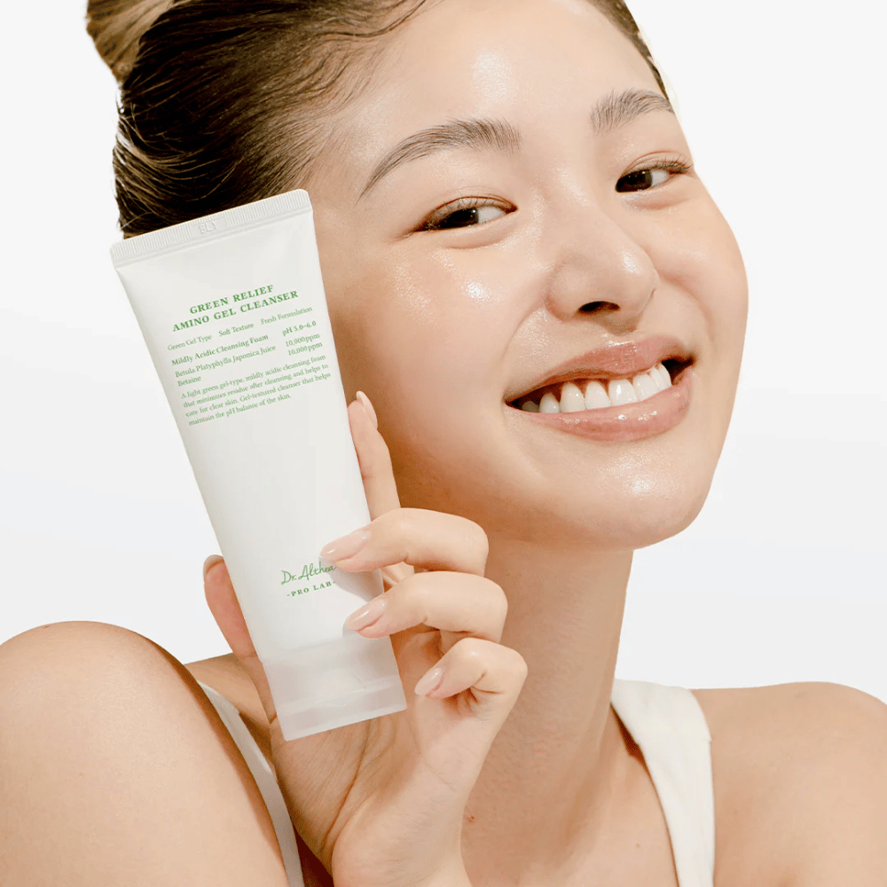 Kvinna med strålande hud håller upp Dr. Althea Green Relief Amino Gel Cleanser – vegansk rengöring för känslig och irriterad hud.