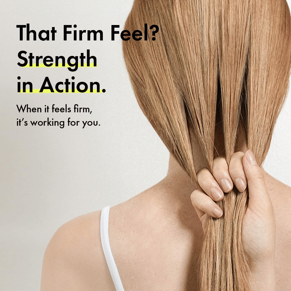 Person håller i sitt hår för att illustrera starkare hårstrån och en fastare hårkänsla efter användning av Grabity g0.0 Hair Lifting Shampoo Strong.