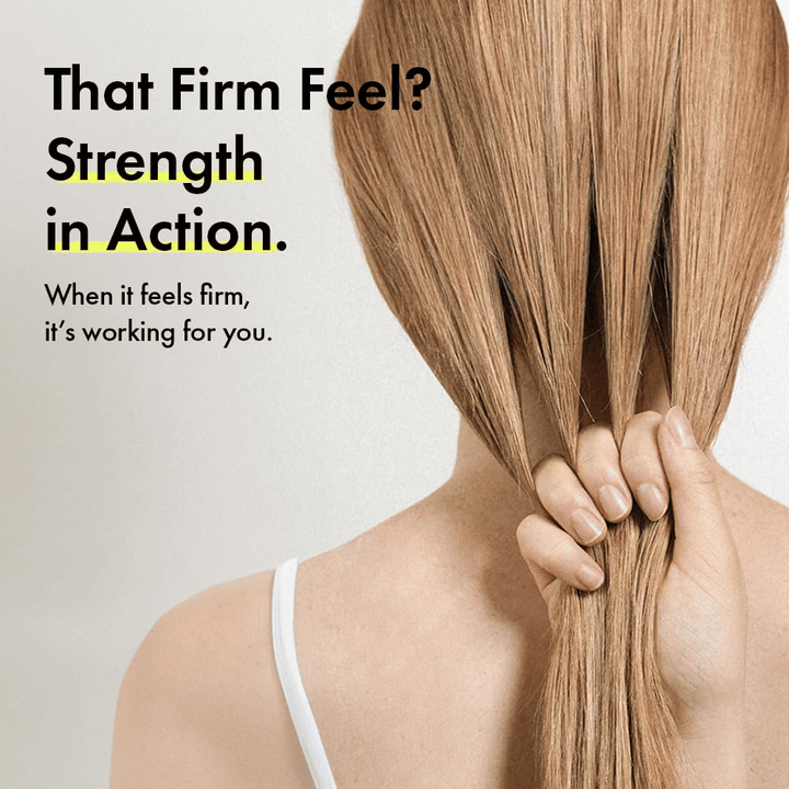 Person håller i sitt hår för att illustrera starkare hårstrån och en fastare hårkänsla efter användning av Grabity g0.0 Hair Lifting Shampoo Strong.