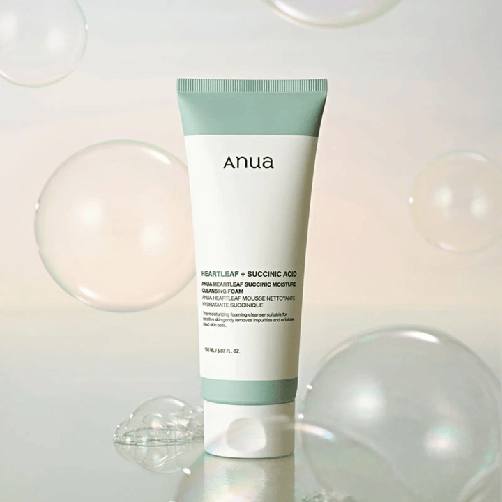 Produktbild av Anua Heartleaf + Succinic Acid Moisture Cleansing Foam omgiven av transparenta bubblor. Bilden förstärker känslan av mild rengöring, fräschhet och ett luftigt skum.
