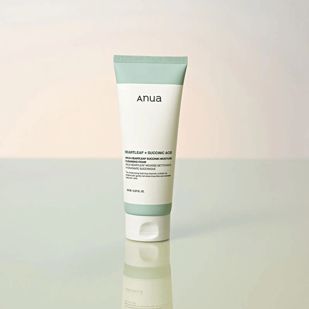 Fristående produktbild av Anua Heartleaf + Succinic Acid Moisture Cleansing Foam. Produkten visas stående på en reflekterande yta som tydligt lyfter fram förpackningens design och varumärkets stilrena estetik.