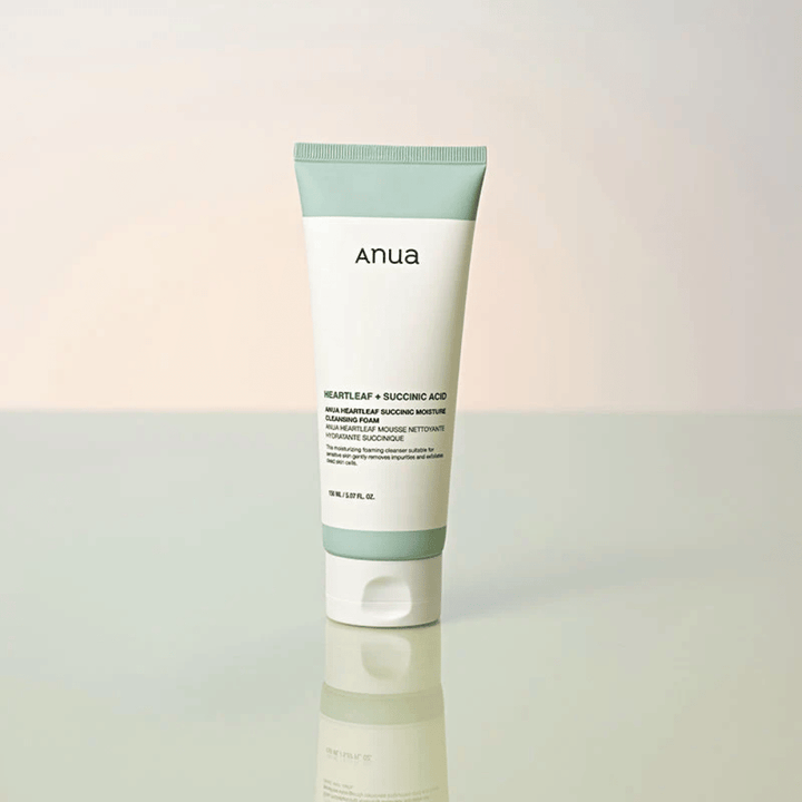Fristående produktbild av Anua Heartleaf + Succinic Acid Moisture Cleansing Foam. Produkten visas stående på en reflekterande yta som tydligt lyfter fram förpackningens design och varumärkets stilrena estetik.