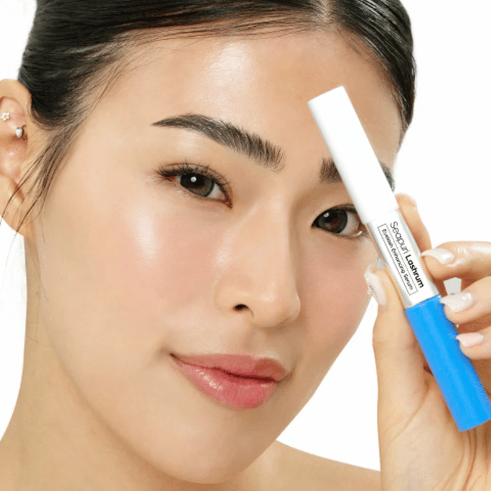Kvinna håller i Seapuri Lashrum Eyelash Enhancing Serum. Ett vårdande fransserum som stärker och definierar fransarna.