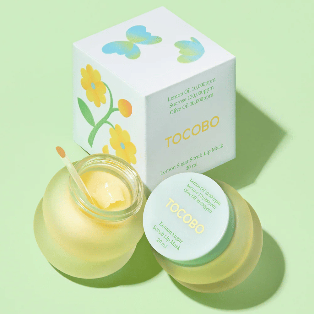 Tocobo Lemon Sugar Scrub Lip Mask tillsammans med sin förpackning med blomdesign på en ljusgrön bakgrund.