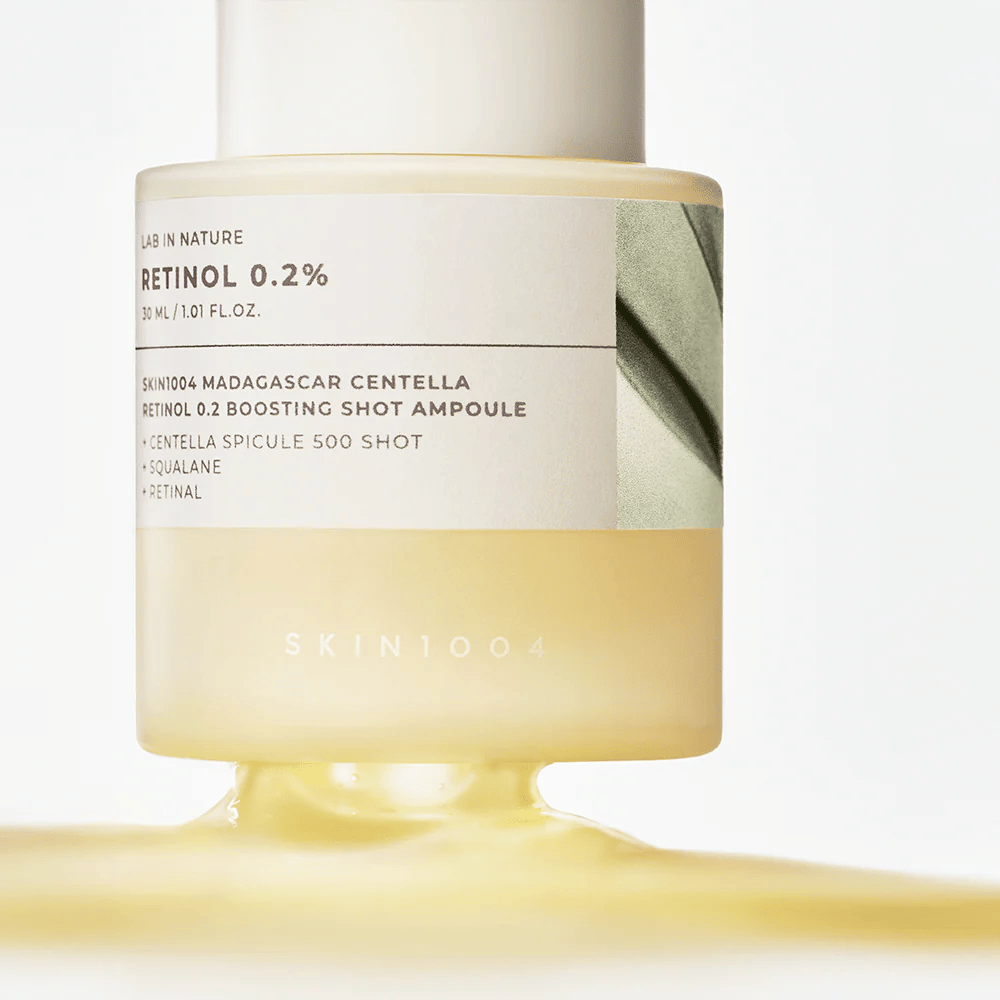 Närbild på SKIN1004 Madagascar Centella Retinol 0.2 Boosting Shot Ampoule som visar den lättgula, silkeslena konsistensen hos retinolserumet för nattlig hudförnyelse.