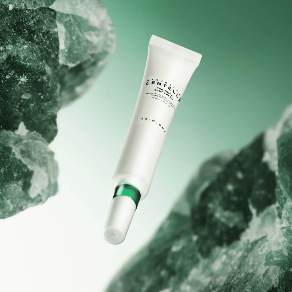 SKIN1004 Madagascar Centella Tea-Trica Spot Cream 20 ml mot akne och finnar, produktbild med grön bakgrund och kristallstruktur – lugnande punktbehandling med centella asiatica och tea tree.