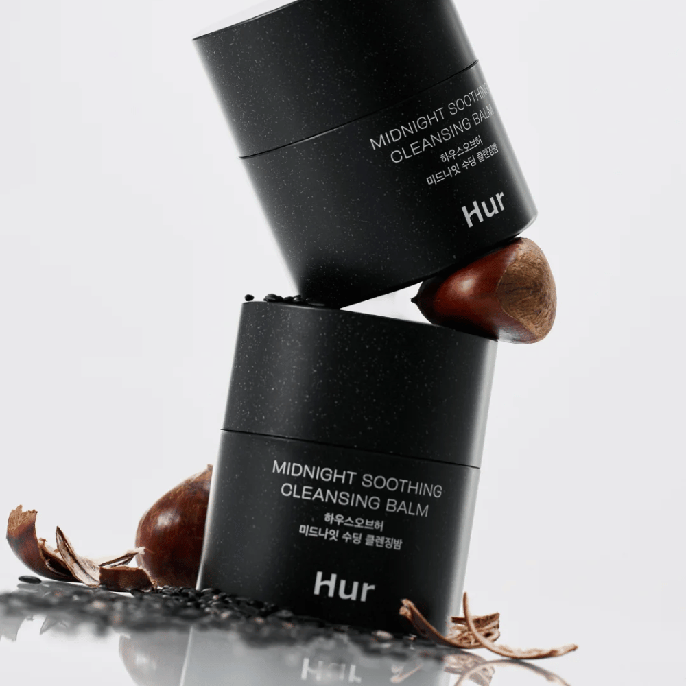 Två burkar Hur Midnight Soothing Cleansing Balm staplade med naturliga ingredienser. Närande cleansing balm för daglig rengöring av känslig hud.