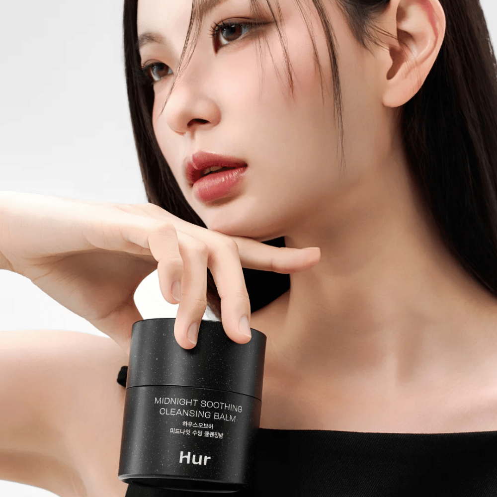 Modell håller Hur Midnight Soothing Cleansing Balm. Koreansk rengöringsbalm som effektivt tar bort smink och rengör huden utan irritation.