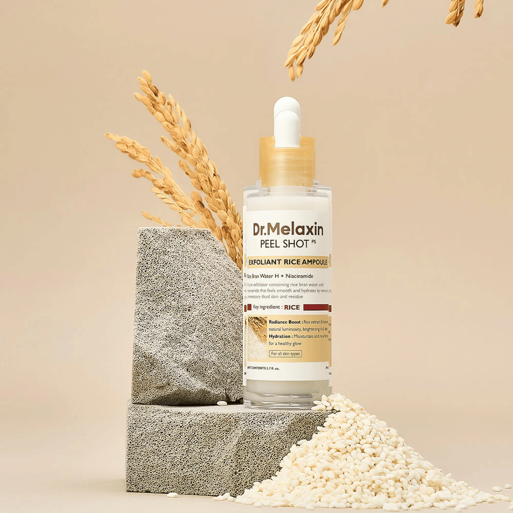 Dr.Melaxin Peel Shot Exfoliant Rice Ampoule uppställd med ris och stenblock, koreansk exfolierande ampull med risextrakt och niacinamid för klarare och mjukare hud.