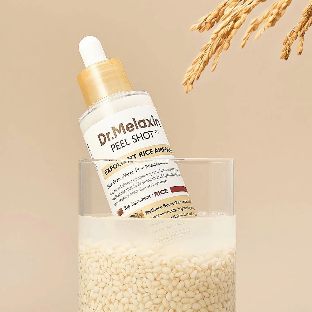 Dr.Melaxin Peel Shot Exfoliant Rice Ampoule placerad i glas med ris, illustrerar risextraktets lystergivande och återfuktande egenskaper inom koreansk hudvård.