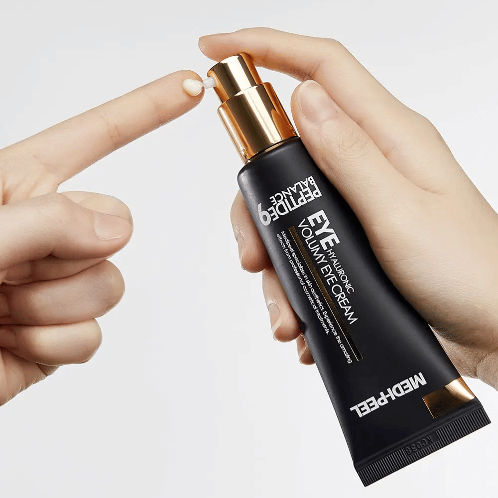 Applicering av MEDI-PEEL Peptide 9 Hyaluronic Volumy Eye Cream på fingertopp – återfuktande ögonkräm med peptidkomplex som hjälper till att minska fina linjer och ge plumpad hud.