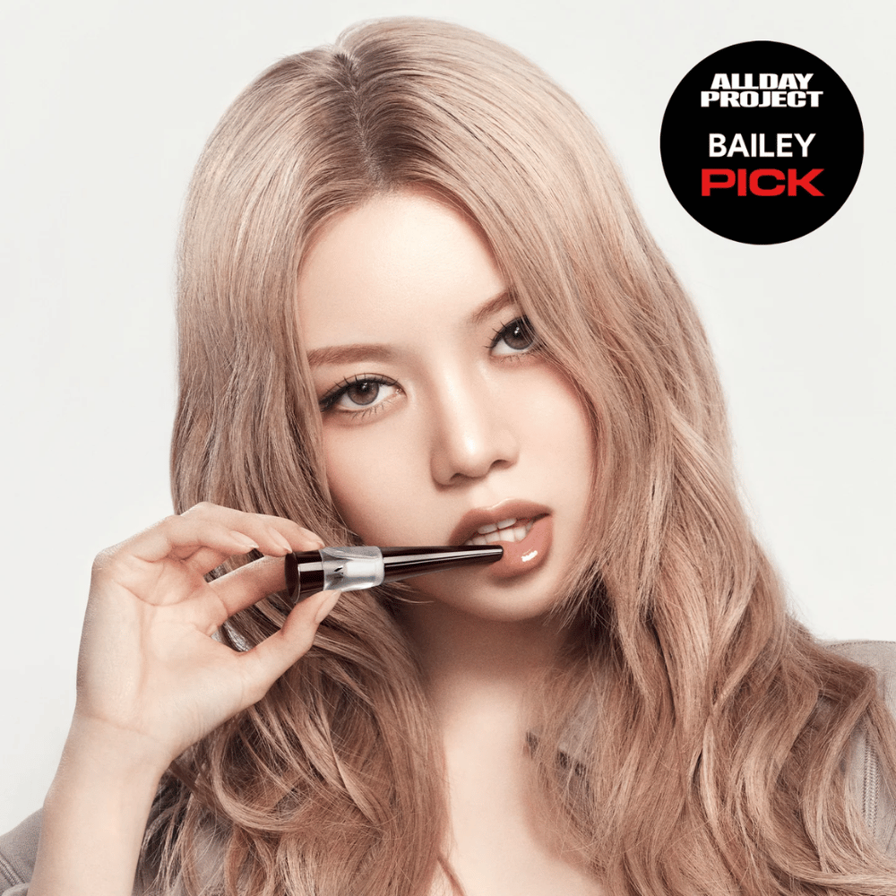 Modell applicerar VT Reedle Shot Lip Plumper Expert på läpparna, glansig finish och fylligare läppar, markerad som Bailey Pick från All Day Project.