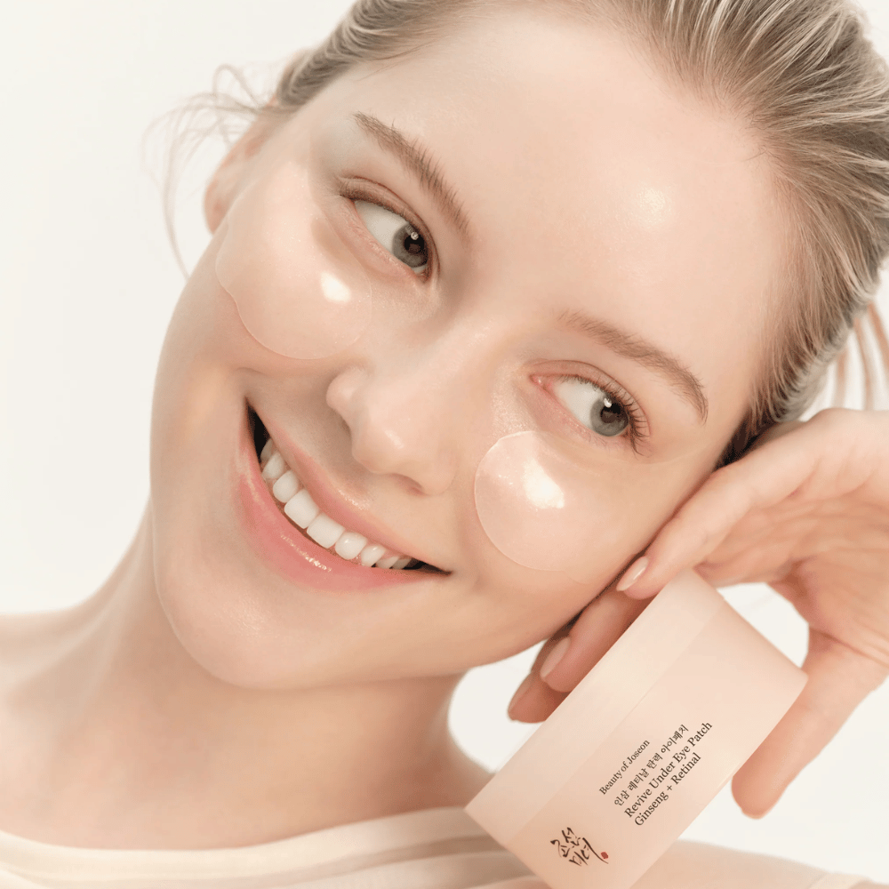 Modell med Beauty of Joseon under eye patches och produkt i handen, ögonpatches med ginseng och retinal för piggare och slätare ögonområde.
