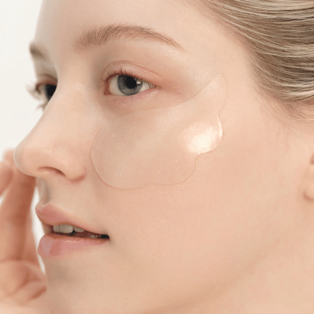 Närbild på modell som applicerar Beauty of Joseon under eye patch under ögat för återfuktning, lyster och uppstramande effekt.