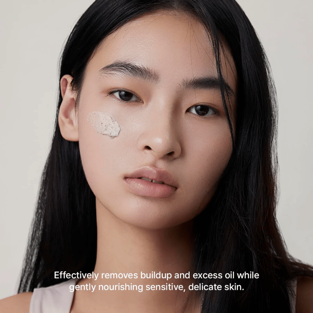 Modell med Arencia Rice + LHA Pore Control Rice Cake Cleanser applicerad på kinden, mild ansiktsrengöring som effektivt avlägsnar smuts och överflödigt sebum utan att torka ut huden.