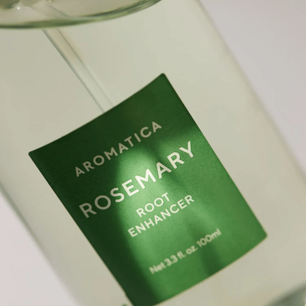 Detaljbild av etiketten på AROMATICA Rosemary Root Enhancer. Den gröna etiketten och den transparenta flaskan framhäver produktens rena och minimalistiska utseende.